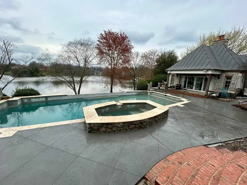 Broom-finish concrete pool deck with stone borders at a Lake Norman home — Old North Concrete Co.